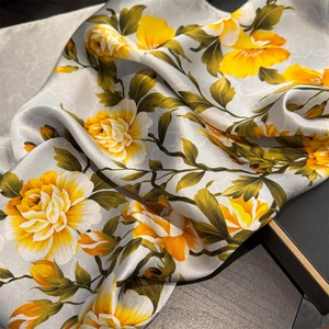 Luxurious silver silk scarf with yellow floral patterns and smooth satin texture for women