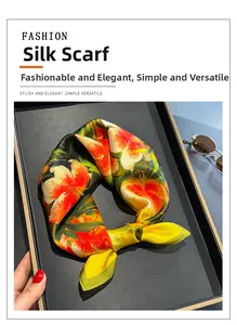 Detail of silk square scarf with vibrant orange lily floral print and satin finish