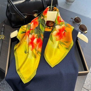 Luxurious silk square scarf featuring vibrant lily prints in yellow and green tones