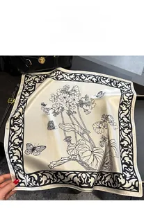 Close-up of vintage floral and butterfly pattern on silky off-white square silk scarf