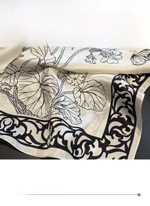 Detailed view of the fine stitched edges and butterfly print on silk square scarf