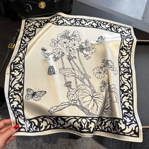 Retro silk scarf with butterfly print and floral border displayed on marble surface