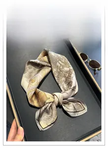 Detailed view of vintage silk square scarf with golden architectural print and brown border