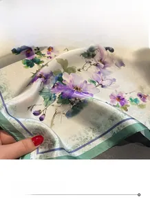 Détail d'un foulard en soie avec motifs floraux et bords ourlés avec précision