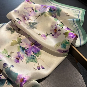 Gros plan d'un foulard en soie avec fleurs à l'aquarelle sur un support minimaliste