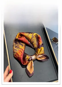 Close-up of luxury mulberry silk square scarf with red and gold mountain print