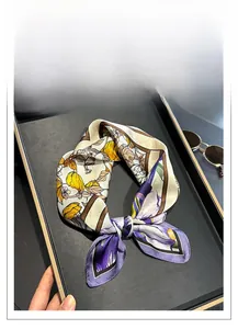 Close-up of a floral silk scarf with yellow and purple flowers on a display tray