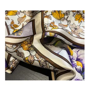 Detailed view of floral silk scarf featuring elegant yellow flowers and smooth texture