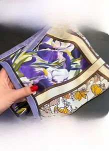 Detail of hand-finished edges on a floral iris printed silk scarf with smooth texture