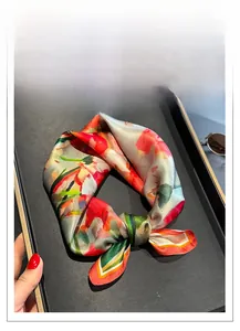 Macro view of 100% mulberry silk scarf with floral patterns on a black display tray