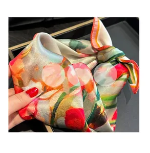 Detail of 100% mulberry silk square scarf with vibrant floral prints and smooth texture