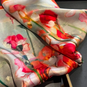 Macro shot of 100% mulberry silk scarf with vibrant red floral print and smooth texture