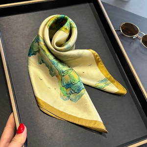 Elegant landscape print 100% silk neckerchief with yellow rolled edges displayed on a tray