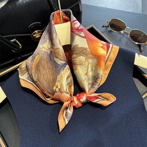 Elegante pañuelo de seda con estampado de peonías anudado sobre un chaleco azul marino