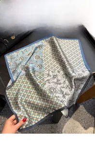 Détail d'un foulard en soie rétro avec texture satinée posé sur un sac en cuir