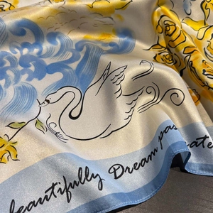 Detail of silk scarf with swan, waves and floral motifs in smooth satin texture
