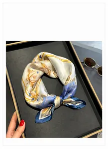 Detail of elegant silk square scarf with floral print and silky texture on tray