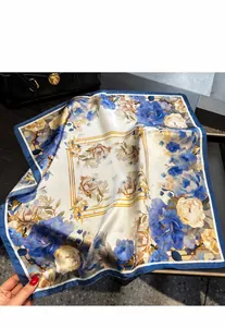 Detailed view of a vintage floral silk square scarf elegantly paired with a leather bag