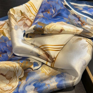 Elegant floral silk scarf in royal blue and yellow with smooth satin finish texture