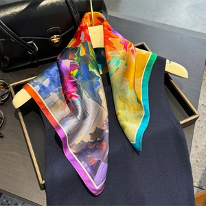 Élégant foulard en soie avec imprimé floral abstrait sur un gilet bleu marine et cintre
