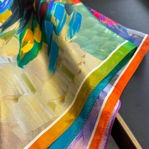 Détail macro d'un foulard en soie avec imprimés abstraits et bords roulottés à la main