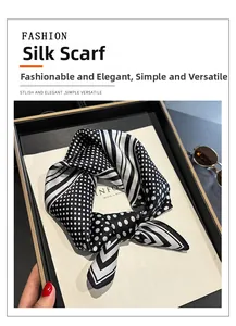 Detailed view of silk square scarf featuring black polka dots and striped edge design