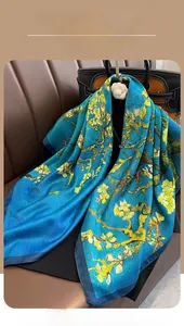 Detail of silk scarf with Van Gogh Almond Blossom print draped on a leather bag