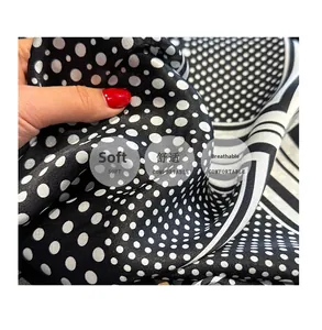 Detail of lightweight black silk scarf with white polka dots and stripes texture