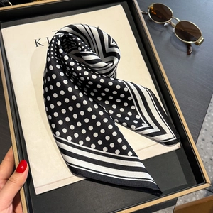 Polka dot silk scarf with black and white geometric pattern on a stylish magazine