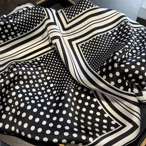 Close-up of polka dot silk scarf showing luxury satin texture and geometric pattern