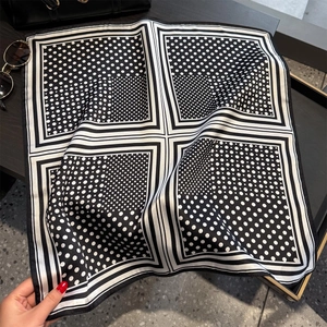 Polka dot silk square scarf in black and white styled with a leather bag and sunglasses