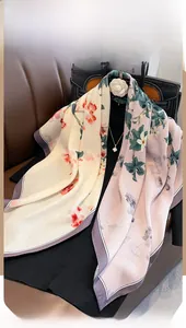 Close-up of floral print silk scarf with floral patterns on a luxury leather bag