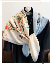 Detail of floral print silk scarf with fine purple stitched edges and camellia brooch