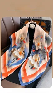 Detail showing the silky texture and elegant white floral print on a large blue silk shawl