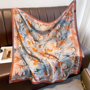 Floral print large square silk shawl with lily patterns on brown leather sofa background