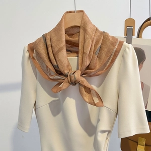 Peach pink silk scarf with vintage totem print styled on a cream dress and wooden hanger