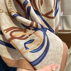 Macro detail of retro square scarf showing golden chains and premium silk texture