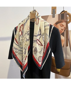 Dettaglio di un foulard in seta vintage con motivi equestri e fibbie dorate
