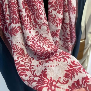 Gros plan détaillé d'un motif damas rétro bordeaux et beige sur un foulard en soie