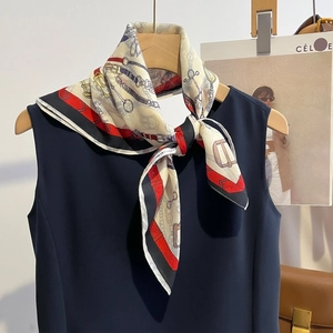 Elegante foulard beige stampato con motivo a briglia su un abito blu scuro
