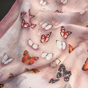 Close-up of lightweight purple scarf featuring butterfly prints and twill weave texture