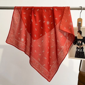 Red paisley scarf with floral patterns for women, hanging elegantly for fashion styling