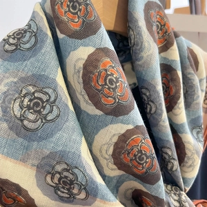 Détail du motif camélia sur une écharpe douce en coton-lin à la texture tissée fine