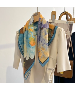 Detailed view of an oil painting style floral silk scarf draped elegantly on a dress