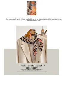 Detail view of cotton linen horse pattern scarf tied elegantly on a beige office blazer