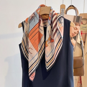 Elegant horse print square scarf with orange and blue accents draped on clothing