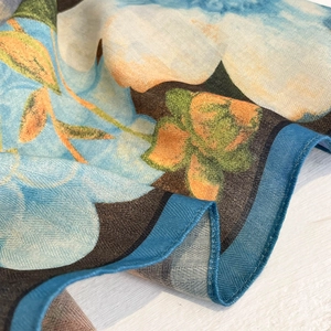 Detailed close-up of oil painting style square scarf showing silk twill texture and blue rolled edges