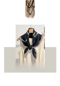 Détail du foulard bleu marine en coton et lin avec motifs géométriques sur un cintre