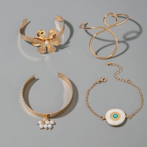 Détail du lot de 4 bracelets dorés vintage avec fleur de perle et charms œil bleu