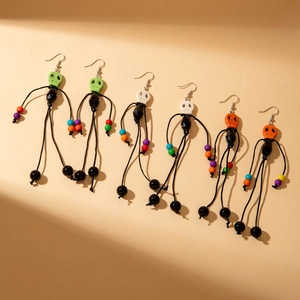 Colorful skull tassel bead earrings for Halloween featuring skeleton charms in green and orange